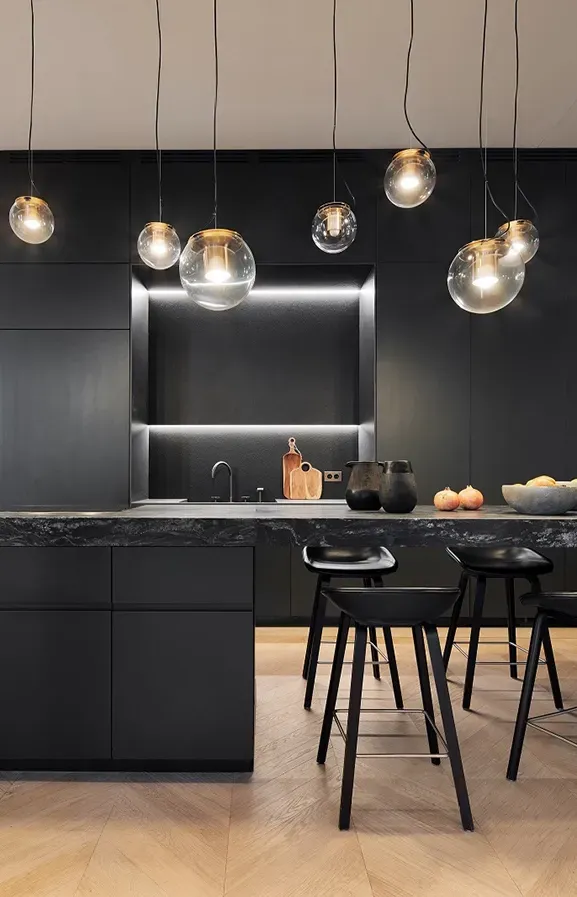 Contemporary black marble kitchen with elegant lighting, highlighting refined luxury.