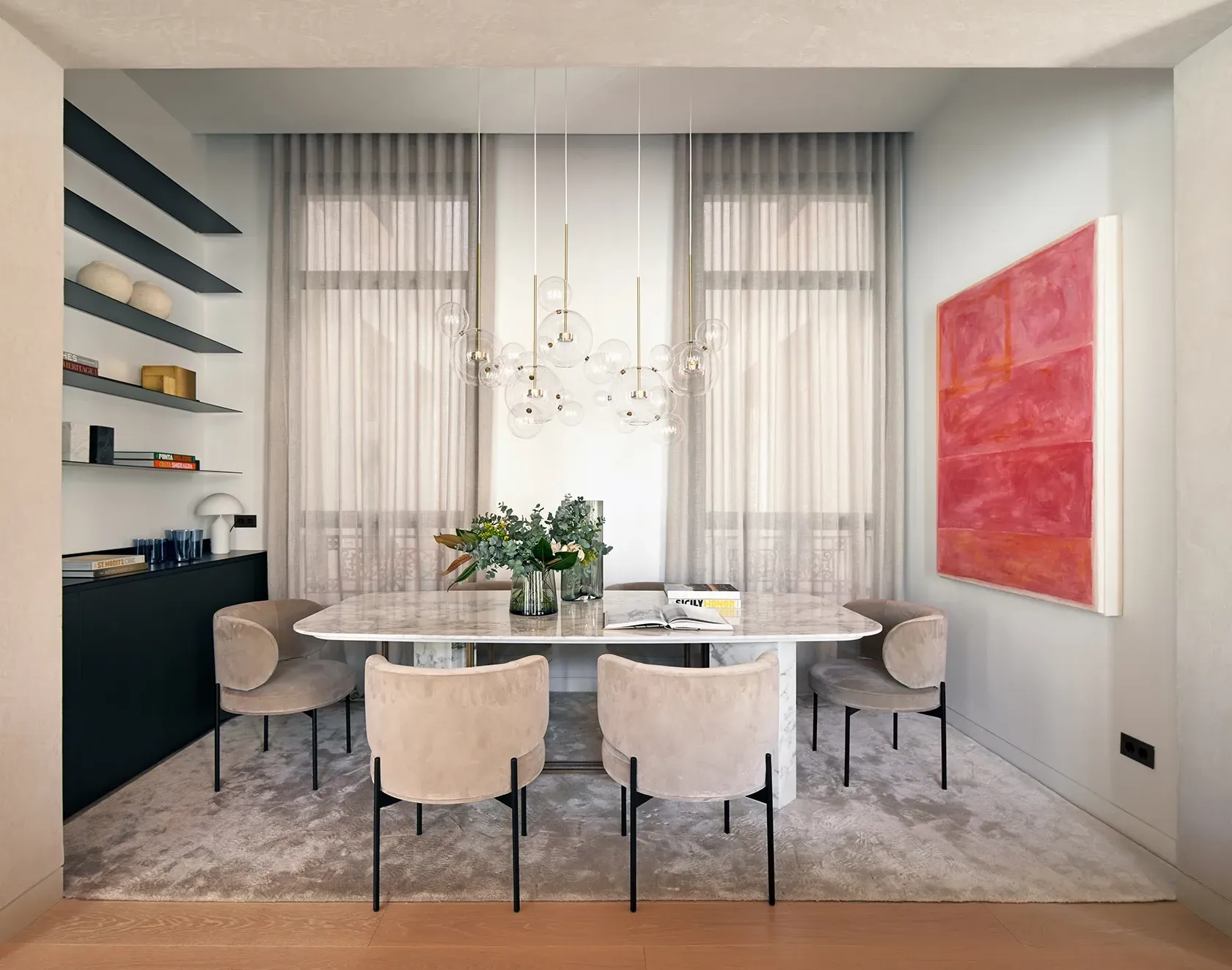 Cozy dining area with modern chandelier and bold artwork, reflecting luxury architecture.