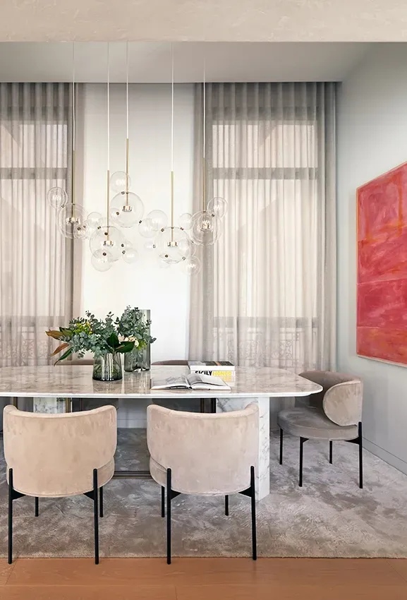 Cozy dining area with modern chandelier and bold artwork, reflecting luxury architecture.