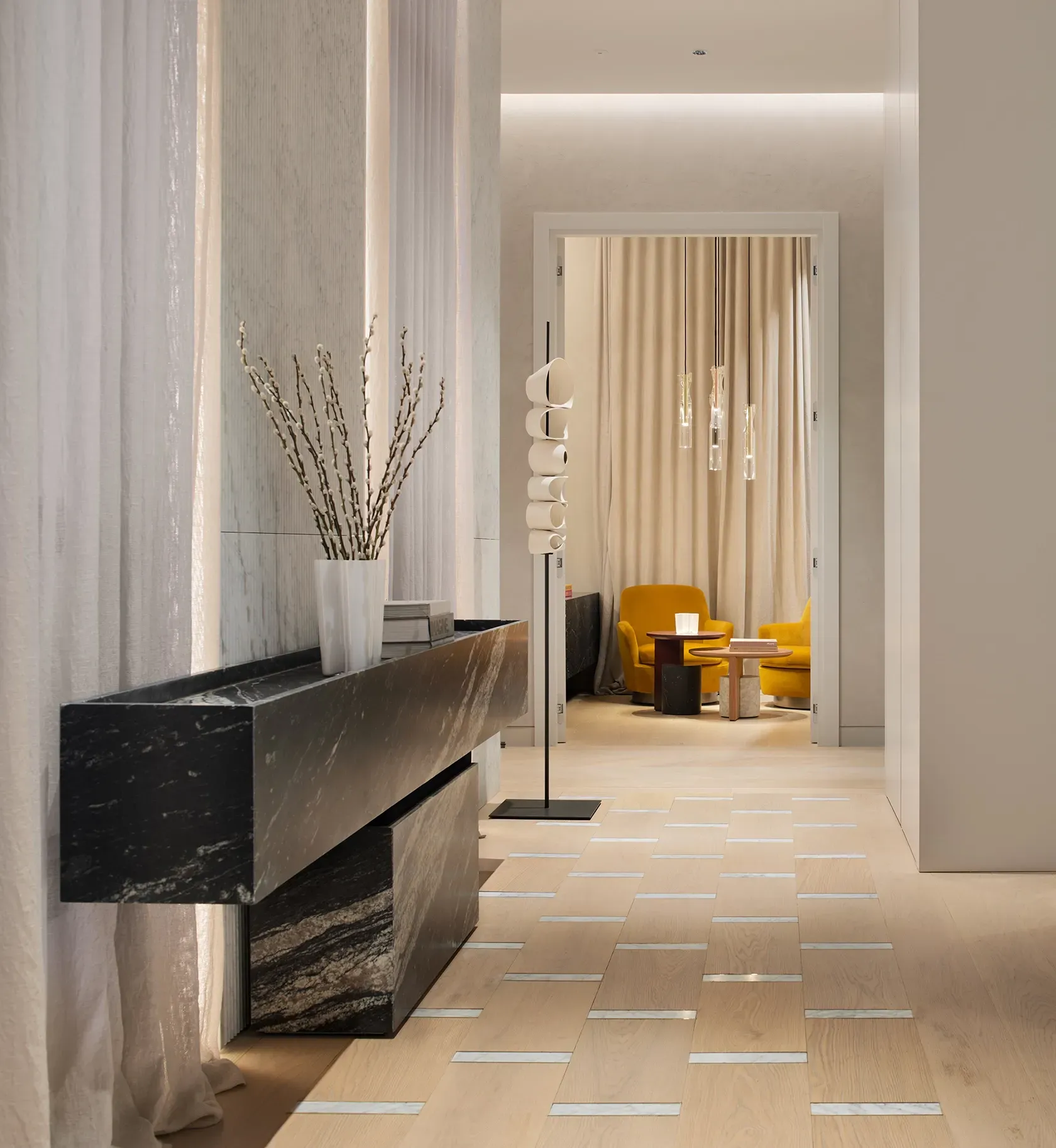 Elegant hallway view into lounge with mustard chairs, blending comfort and modern architecture.