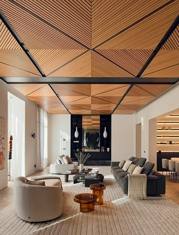 Modern living room with geometric wood ceiling and curated luxury architecture elements.