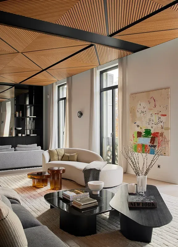Bright living space with curved furniture and abstract art, highlighting luxury interior design.