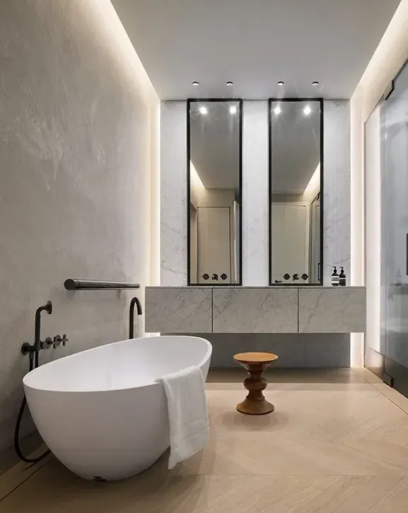 Luxury bathroom with freestanding tub, marble walls, and modern minimalist architecture.