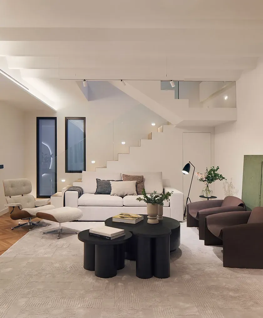 Contemporary living room with elegant staircase and designer furniture in a luxury Pedralbes penthouse.
