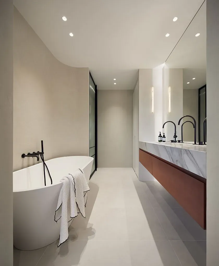 Minimalist bathroom with freestanding tub and marble double sink in a luxury architectural design.