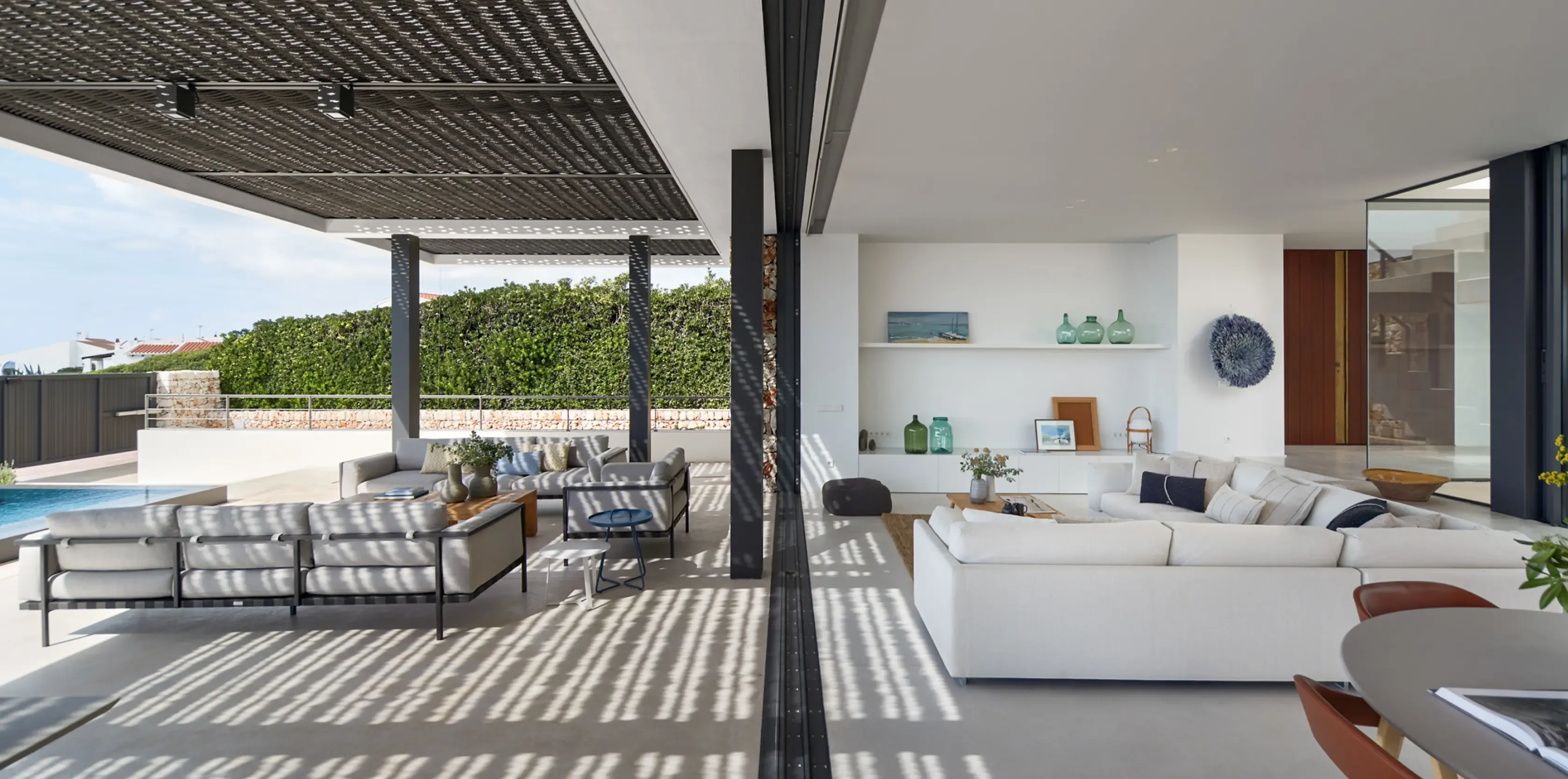 Open-plan living room seamlessly connected to the outdoor area, featuring contemporary furniture and natural textures.