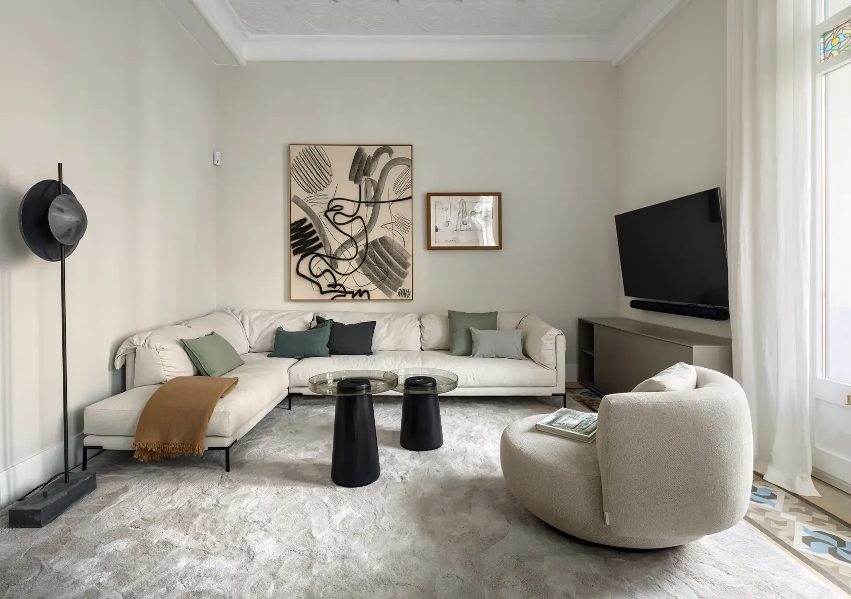 Salón del Apartamento Casa Oller con sofá contemporáneo blanco, butaca tapizada, arte abstracto y mobiliario de diseño.
