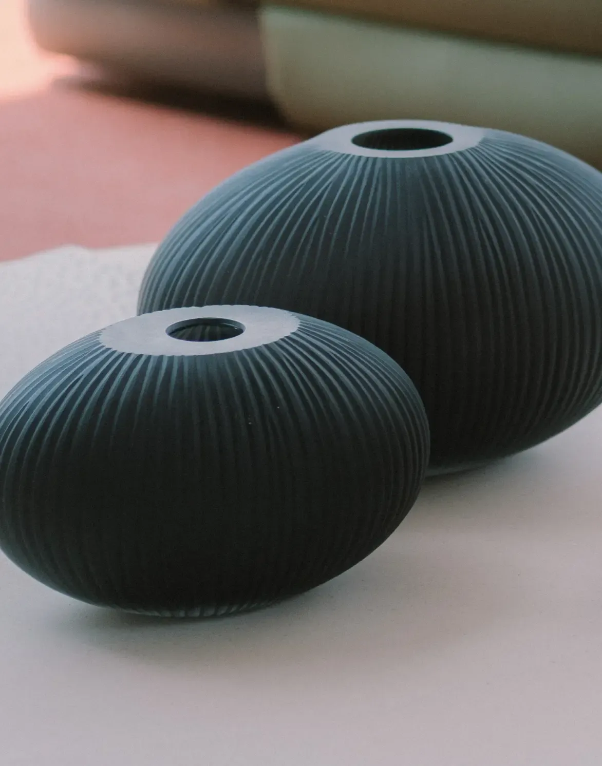 Ceramic vases with organic textures on contemporary sideboard near large window