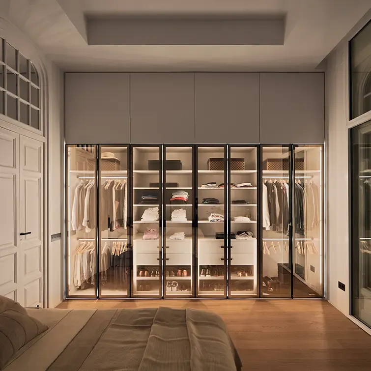 Luxury bedroom with illuminated glass wardrobe, organized shelves, and elegant neutral tones combining comfort with modern sophistication.
