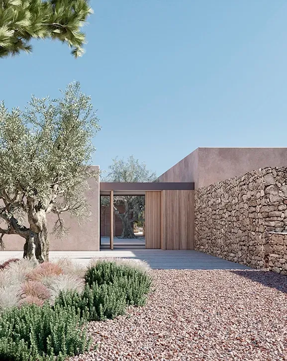 Ibiza villa entrance by LUV Studio with rustic stone walls, native landscaping, and Mediterranean architectural charm.