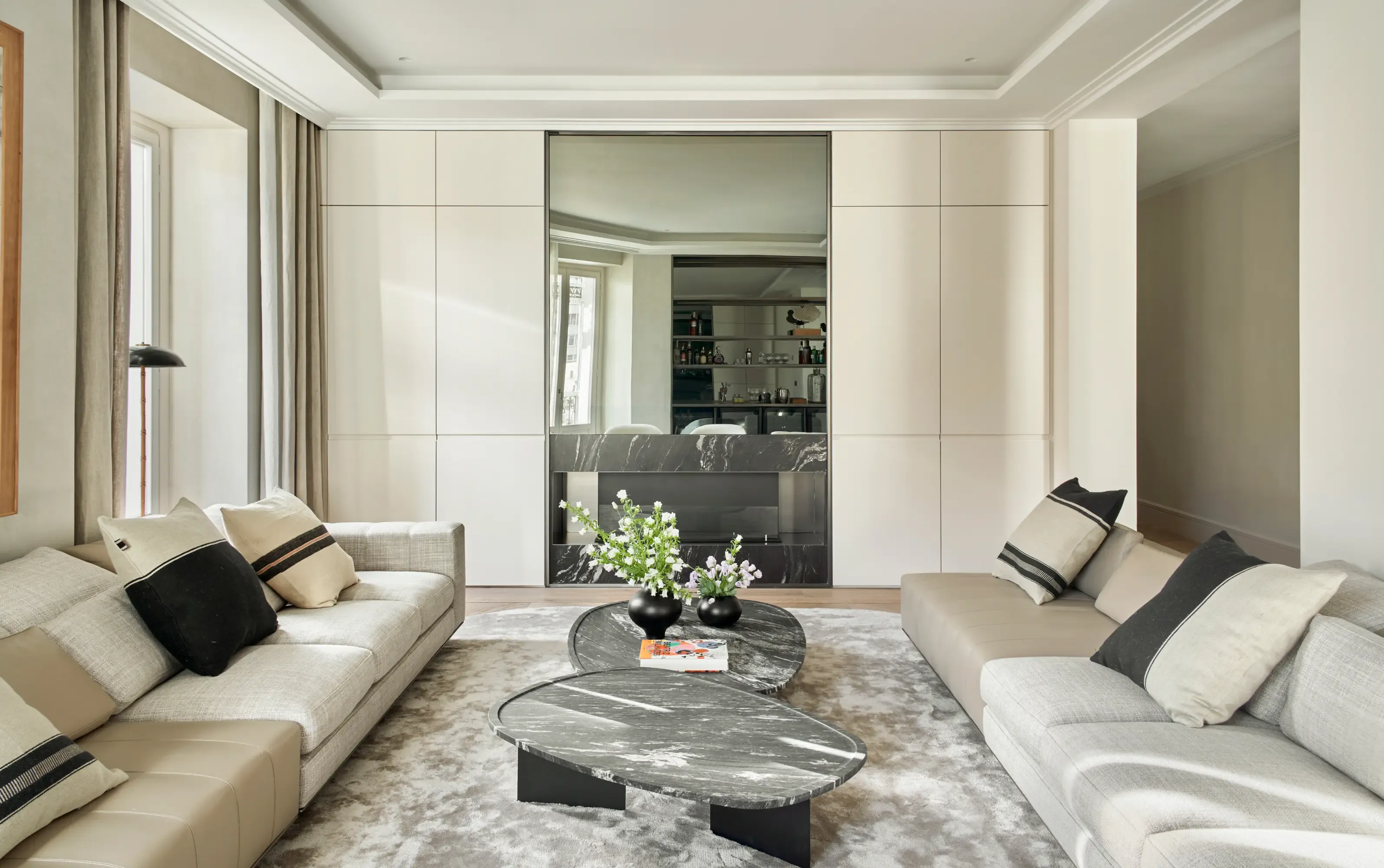 Elegant living room with contemporary sofas, marble coffee tables and neutral tones in a luxury apartment