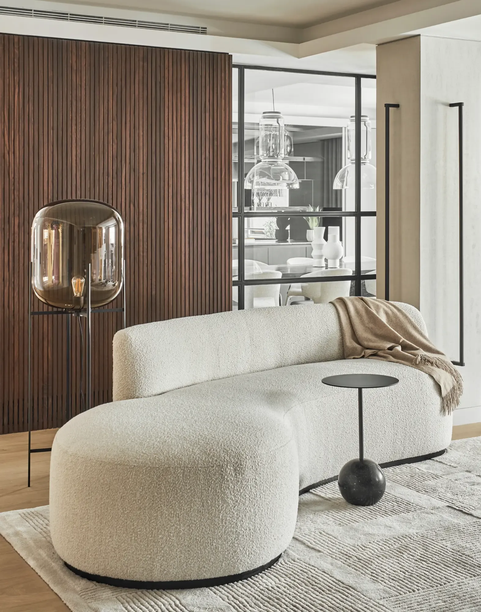 Organic-shaped white sofa with soft textures and modern floor lamp in a refined living room