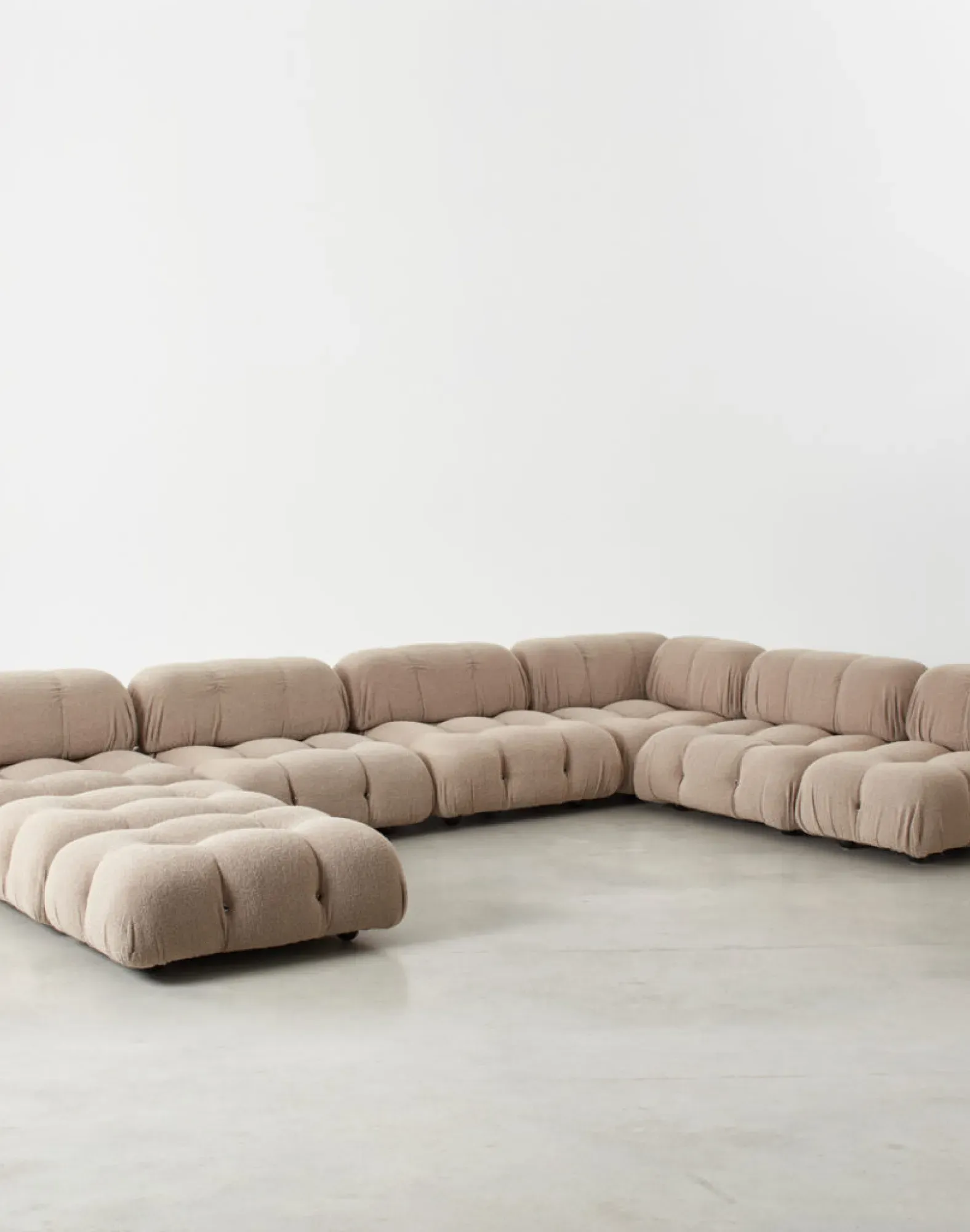 Contemporary lounge with upholstered modular sofa and blue pendant light.